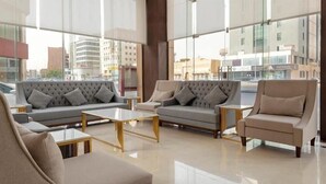 A modern hotel lobby with a sofa set, a coffee table, and a chair. - Seiba Serviced Apartment- Riyadh (Riyadh)