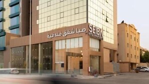 A modern hotel building with a glass facade and a sign indicating it is the Seiba Hotel. - Seiba Serviced Apartment- Riyadh (Riyadh)