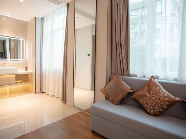 A modern bathroom with a vanity, mirror, and curtains. - GYA Shanghai Jiangpu Hotel (Shanghai)
