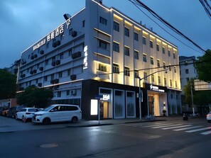 Un hotel de varios pisos con una fachada moderna, que incluye señalización iluminada y una entrada a nivel de calle.