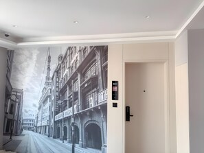 A hallway with a mural of a street scene, a door with a digital lock, and a sign with numbers. - GYA Shanghai Long Distance Passenger Terminal Hotel (Shanghai)