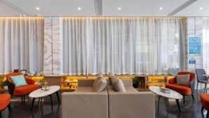 A modern hotel lobby with a sofa, chairs, and a large window with curtains. - VX Xiamen Siming District Huandao Road Hotel (Xiamen)