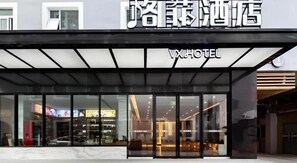 A hotel entrance with a modern design, featuring large glass doors and a sign above that reads 'WX HOTEL'. - VX Xiamen Siming District Huandao Road Hotel (Xiamen)