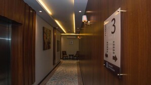 A hallway with wooden paneling, a number 3 sign, and a patterned carpet. - Maset Al Masem Al Khobar (Al Khobar)