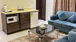 A compact living space with a kitchenette, a sofa, a coffee machine, and a microwave. - Maset Al Masem Al Khobar (Al Khobar)