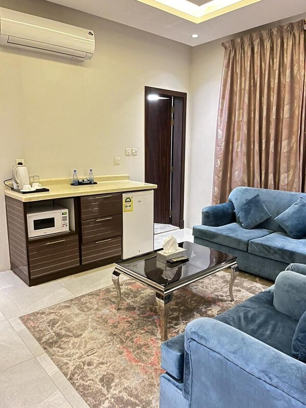 A compact living space with a kitchenette, a sofa, a coffee machine, and a microwave. - Maset Al Masem Al Khobar (Al Khobar)