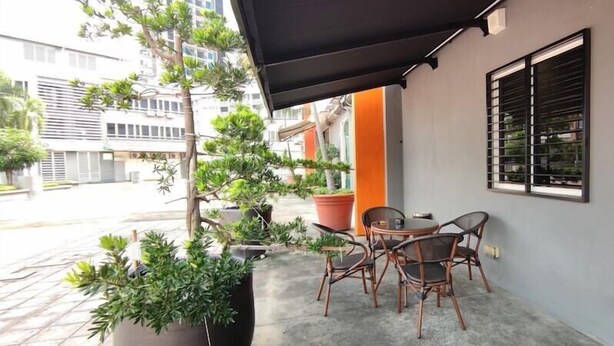 Een balkon met plantenbakken, een tafel en stoelen.
