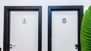 Twee deuren, waarvan één 'SURAU' en de andere 'BAGAGERUIMTE' staat.