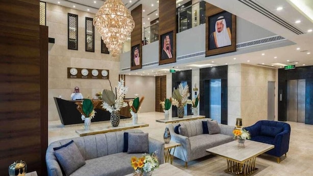 A spacious lobby with multiple seating areas, a reception desk, and a chandelier. - Elian Hotel (Riyadh)