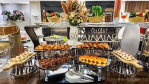 A buffet setup with various food items and a decorative centerpiece. - Elian Hotel (Riyadh)