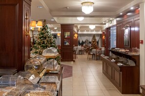 A hotel lobby with a buffet area, Christmas tree, and a Christmas market setup. - Lingos Hotel (Florina)