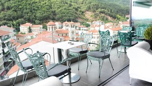 Un balcón con vistas a un pueblo y montañas.