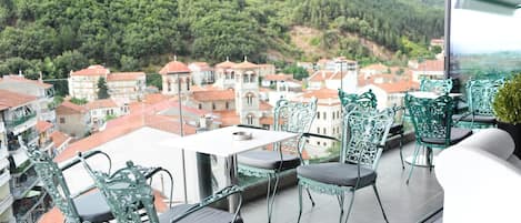 Un balcón con vistas a un pueblo y montañas.