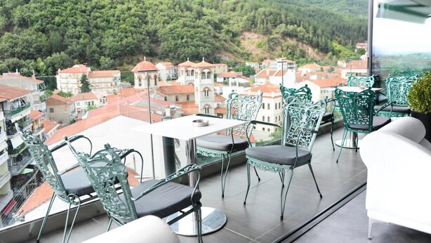 A balcony with a view of a town and mountains.