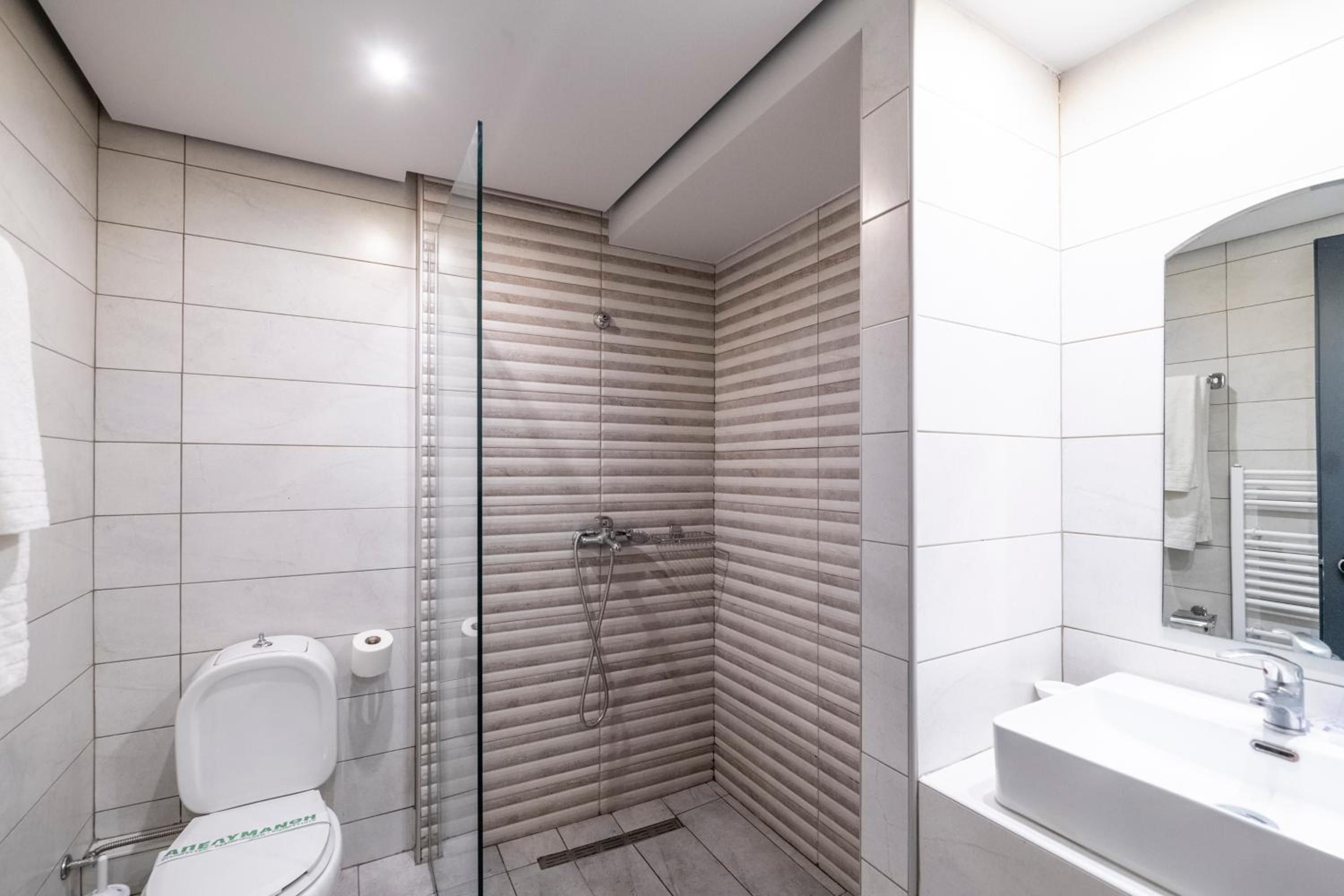 A modern bathroom with a shower, toilet, and sink.