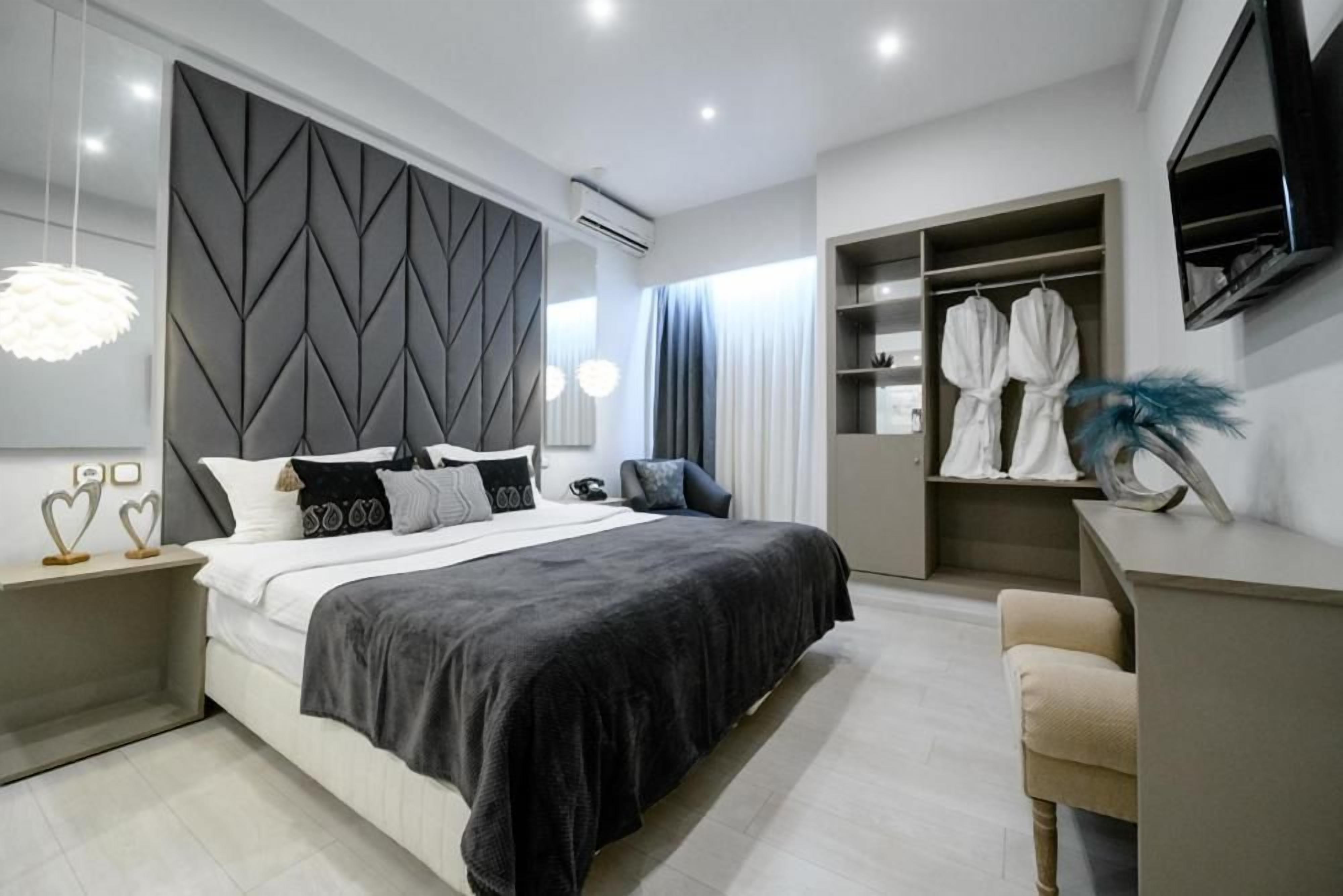 A modern bedroom with a bed, bedside tables, a wardrobe, and a desk.