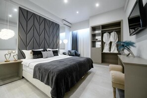 A modern bedroom with a bed, bedside tables, a wardrobe, and a desk. - Lingos Hotel (Florina)