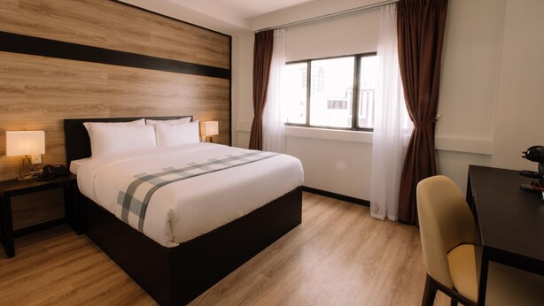 A hotel room with a bed, bedside lamps, a desk, and a window with curtains. - Chotel Ben Thanh (Ho Chi Minh City)