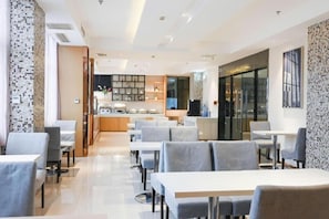 A modern restaurant with a clean, minimalist design, featuring a central bar area and multiple seating options. - City Comfort Inn (Wuhan)