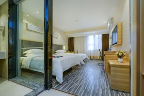 A hotel room with two beds, a desk, a mirror, and a window with curtains. - City Comfort Inn (Chongqing)