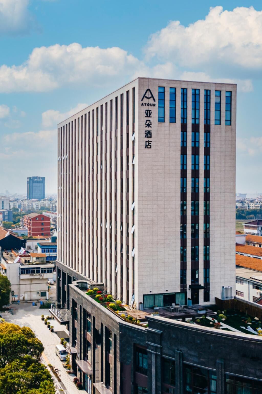 Ein modernes Hotelgebäude mit einer vertikalen Fassade, großen Fenstern und einem Schild, das es als Hotel kennzeichnet.