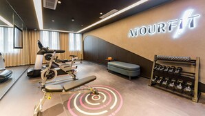A gym with exercise equipment, a bench, a wall-mounted dumbbell rack, and a wall with the text 'MOURFIT'. - Atour Hotel Haifeng Road Haiyan Jiaxing (Jiaxing)