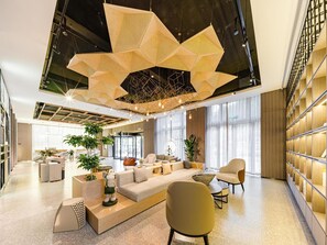 A modern lobby with a geometric ceiling design, a seating area with sofas and chairs, and a reception desk. - Atour Hotel Haifeng Road Haiyan Jiaxing (Jiaxing)