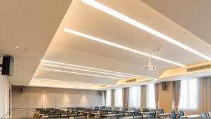 A conference room with a modern ceiling design, large windows, and a projector. - Atour Hotel Haifeng Road Haiyan Jiaxing (Jiaxing)