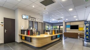 A reception area with a counter, a TV screen, and a sign that reads "Bienvenue, VOUS!" - B&B Hotel Perpignan Saleilles (Saleilles)