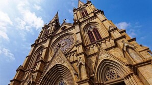 A historic cathedral with intricate stonework, large rose windows, and a prominent clock tower. - Shangyuan Hotel (Guangzhou)
