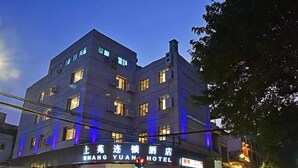 A multi-story hotel with illuminated signage, a visible entrance, and a street view with traffic lights. - Shangyuan Hotel (Guangzhou)