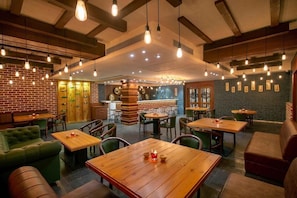A cozy restaurant with brick walls, wooden tables, and green seating. - Bloom Boutique Ranjit Avenue (Amritsar)
