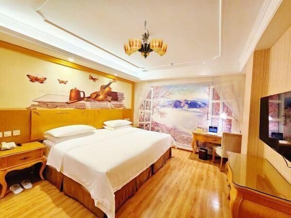 Ein Hotelzimmer mit Bett, Schreibtisch, Stuhl, Fernseher und einem Fenster mit Bergblick.