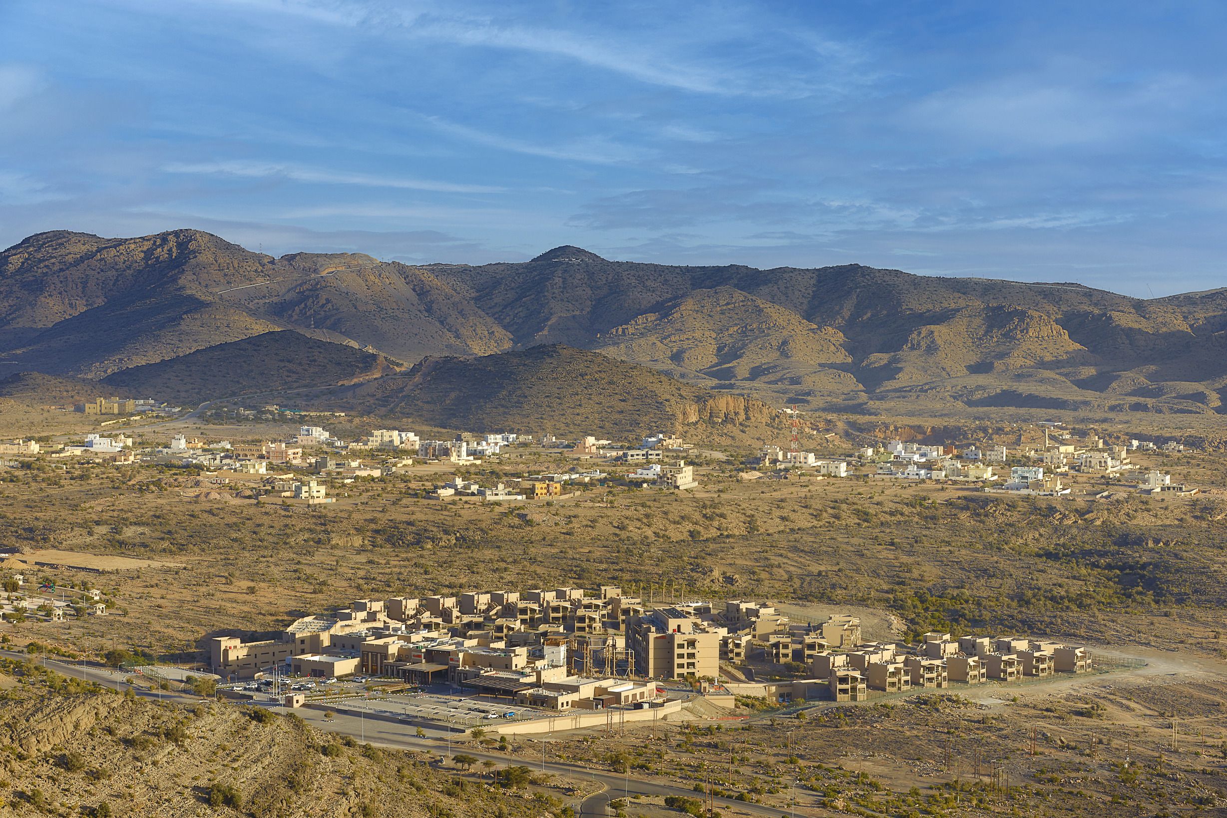 A desert town with buildings and mountains in the background.