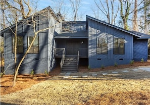 A modern two-story house with a front porch, a staircase leading to the entrance, and a well-maintained yard. - Travel Nurse & Military Housing, 2BR 4Bed Calm Retreat, 10 mins to Fort Liberty (Fayetteville)