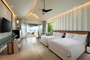 A modern hotel room with a large bed, a TV, a desk, and a view of the sea. - Hilton Maldives Amingiri Resort and Spa (Amingiri)