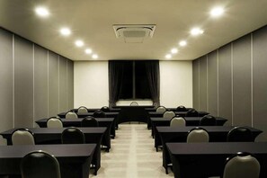 A conference room with a long table, chairs, a projector screen, and a ceiling-mounted air conditioning unit. - Vila Gale Alagoas (Barra de Santo Antonio)