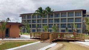 A hotel with a central courtyard, palm trees, and a bridge. - Vila Gale Alagoas (Barra de Santo Antonio)