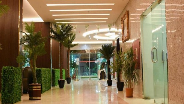 A hotel lobby with a polished floor, potted plants, and a glass entrance. - Florida Inn Najran (Nejran)