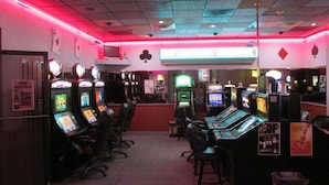 A room with multiple gaming machines, chairs, and a carpeted floor. - Americas Best Value Inn Billings (Billings)