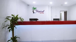 Ein Empfangsschalter mit roter Oberfläche und dem Logo des Tropical Hotel.