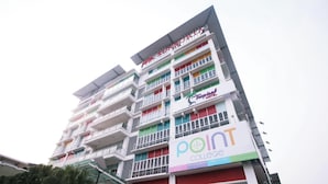 Ein mehrstöckiges Gebäude mit Balkonen, einem Schild mit der Aufschrift Tropical Hotel und einem Schild mit der Aufschrift Point College.