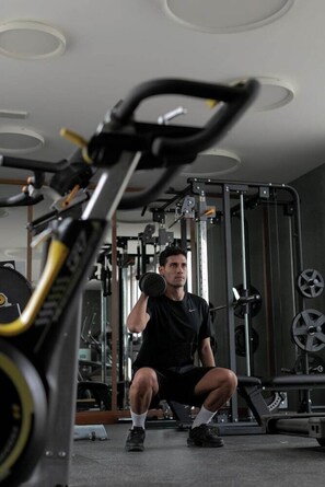 A gym with weightlifting equipment, including a squat rack and dumbbells. - Nivaria Beach Apartments and Villas (Arico)