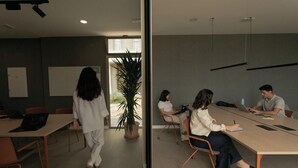 Un salón de conferencias con una larga mesa, sillas y una pizarra.