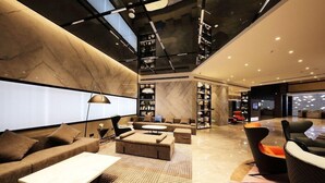 Un interior modern amb un sofà, una taula de cafè i una catifa estampada.