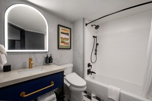 Uma casa de banho moderna com uma pia branca, sanita, banheira e chuveiro.