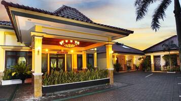 A hotel entrance with a covered porch, a sign reading "SPA ROOM," and a paved driveway.