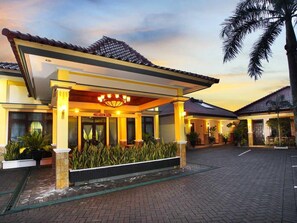 A hotel entrance with a covered porch, a sign reading "SPA ROOM," and a paved driveway. - Ning Tidar Hotel Magelang (Mertoyudan)