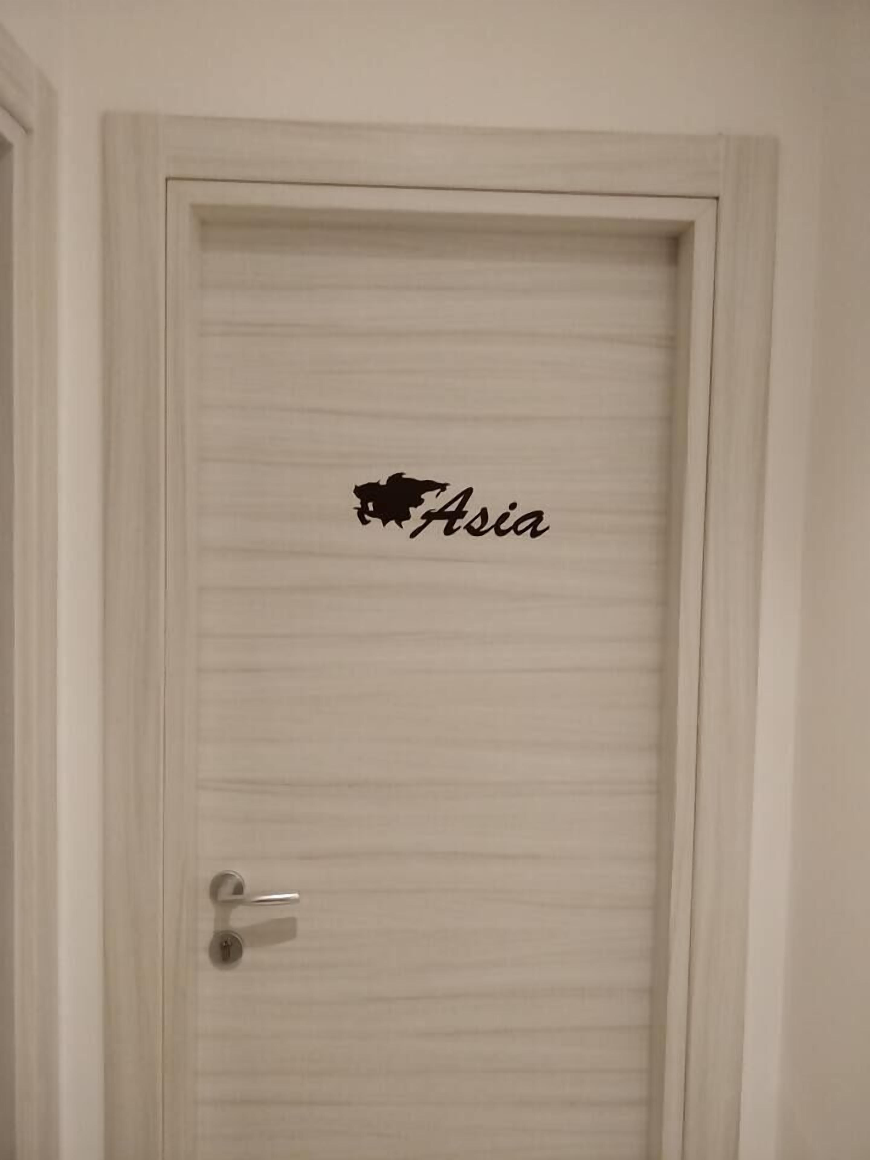 A door with a simple design and a black sticker with the word "Asia" on it.
