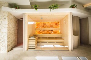 A sauna room with wooden benches and a stone wall. - Hotel San Giacomo Sport & Relax (Paderno del Grappa)